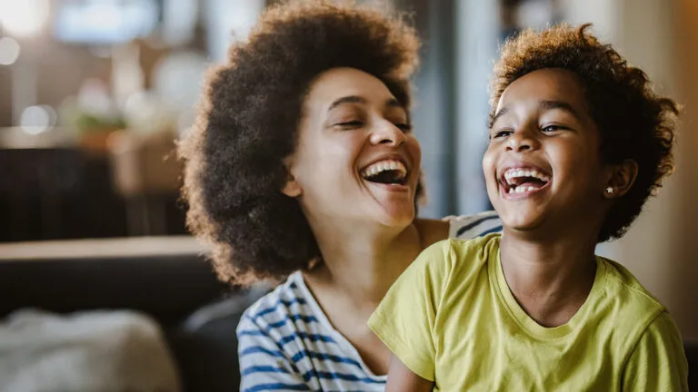 Mother and her young daughter laughing together to be more grateful and happy