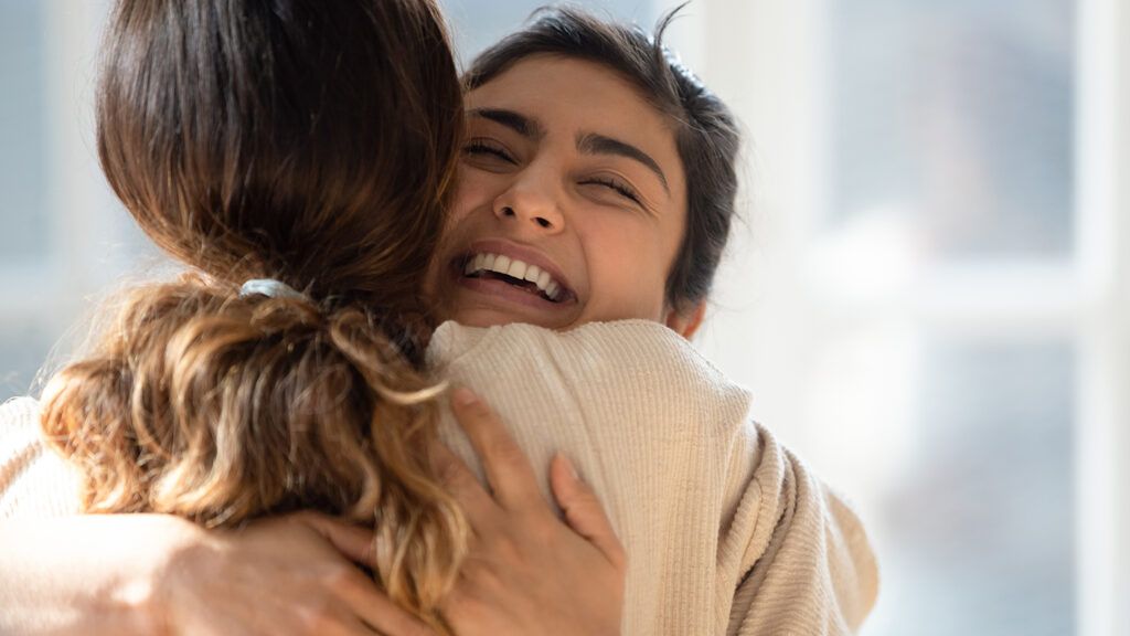Woman hugging her friends to be more grateful