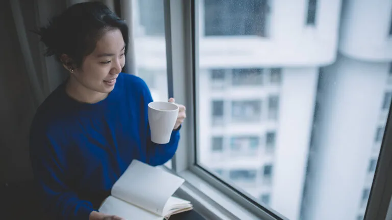 Woman writing down how to be more grateful in her journal