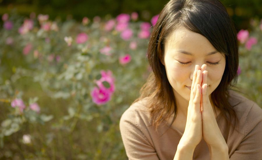 a woman in a garden gives a prayer of thanks