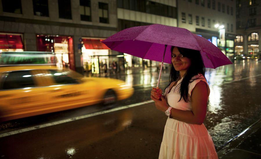 a woman in new york city with an umbrella prepared for a rainstorm