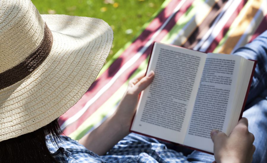 Guideposts: A man wearing a straw hat reads a book in a hammock on a summer afternoon.