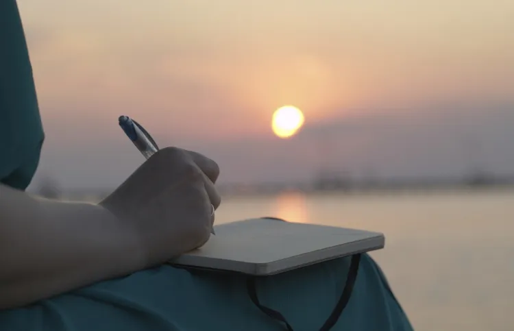 a woman writing her blessings down