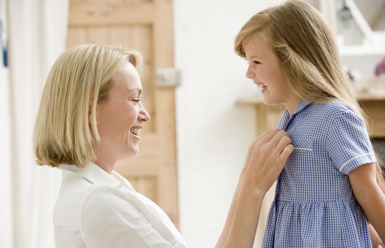 Guideposts: A mom buttons up her young daughter's new dress on the first day of school.