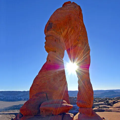 Guideposts: The desert sun peeks through a narrow opening in a red rock arch in Utah