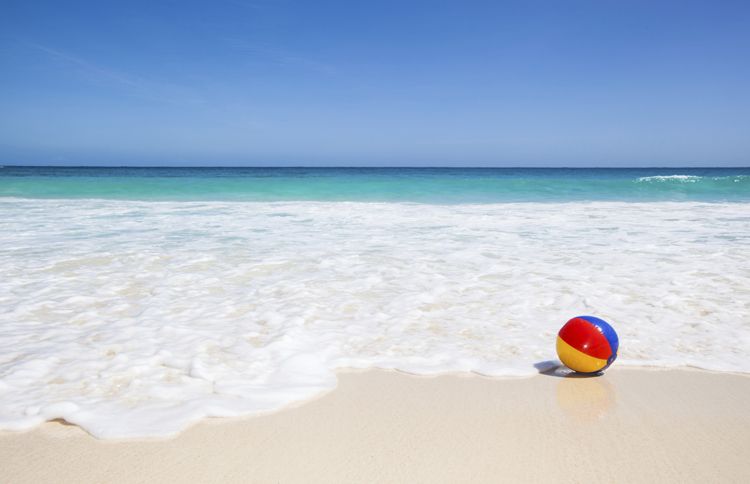 Guideposts: A beach ball floats on the incoming tide on a sunny beach