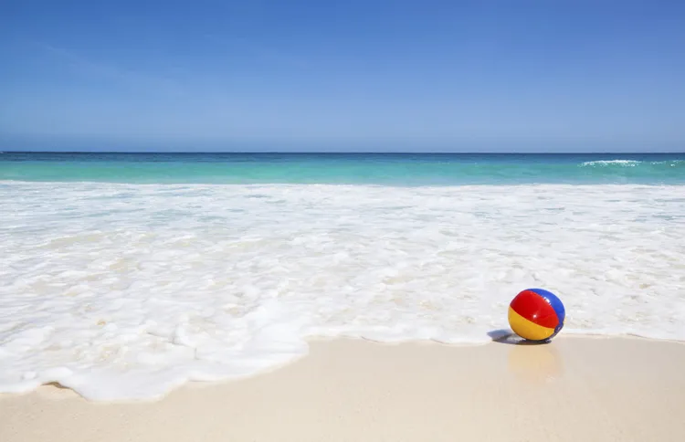 Guideposts: A beach ball floats on the incoming tide on a sunny beach