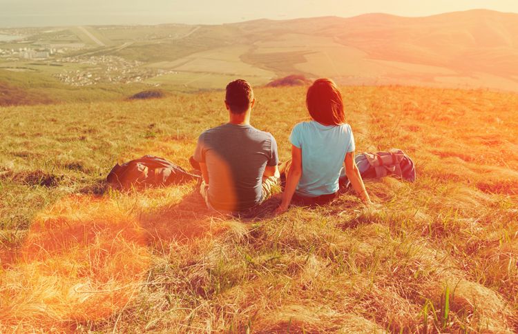 Guideposts: A man and a woman sit together in a sun-drenched field