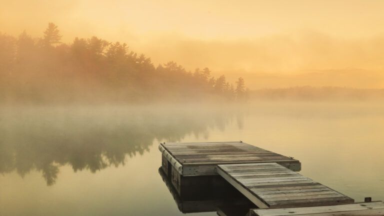 A dock on a lake at sunrise on new year with Bible verses