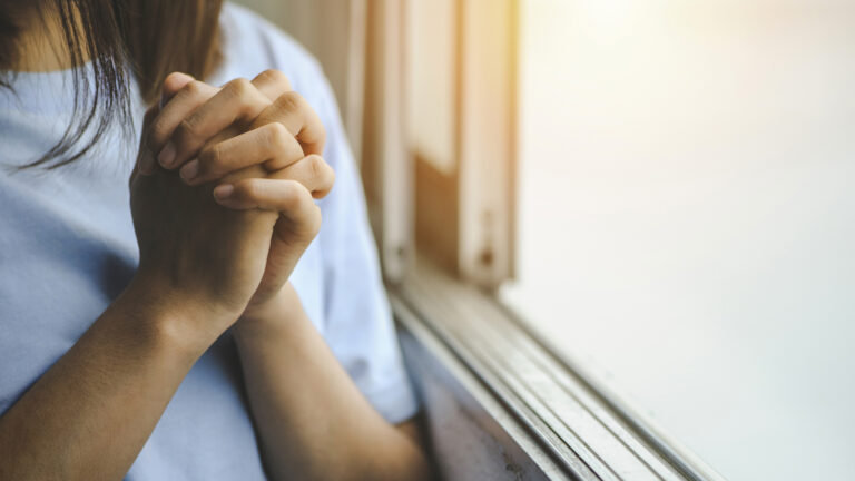 Woman praying by the window to prepare for the new year