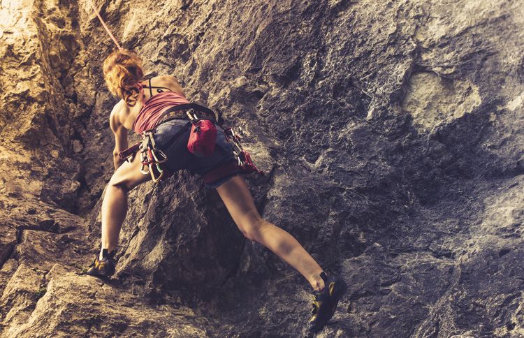 Woman rock climbing with a new year bible verse