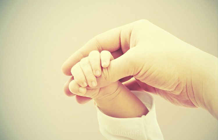 Mother holding baby's hand with a new year bible verse