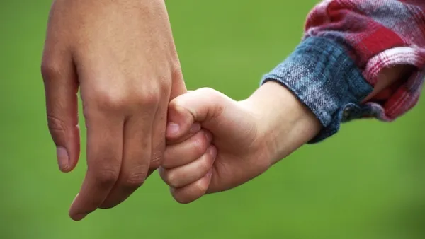 A mother and son share a grateful, peaceful moment in a busy day.