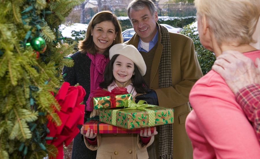 Guideposts: A smiling family bearing Christmas gifts pays a home visit to a person with cancer.