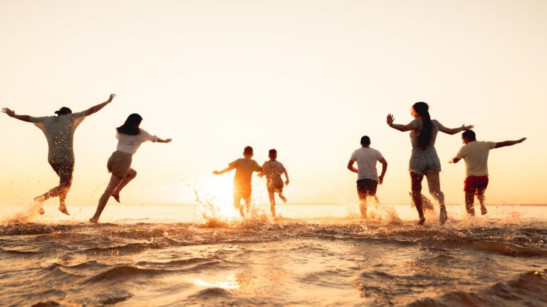 A group of friends run into the ocean after reading Valentine's Day quotes