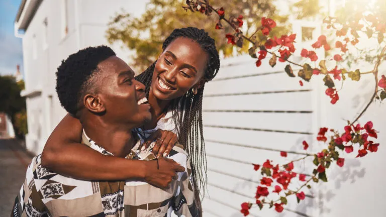 Boyfriend giving his girlfriend a piggy back ride after reading valentine's day quotes