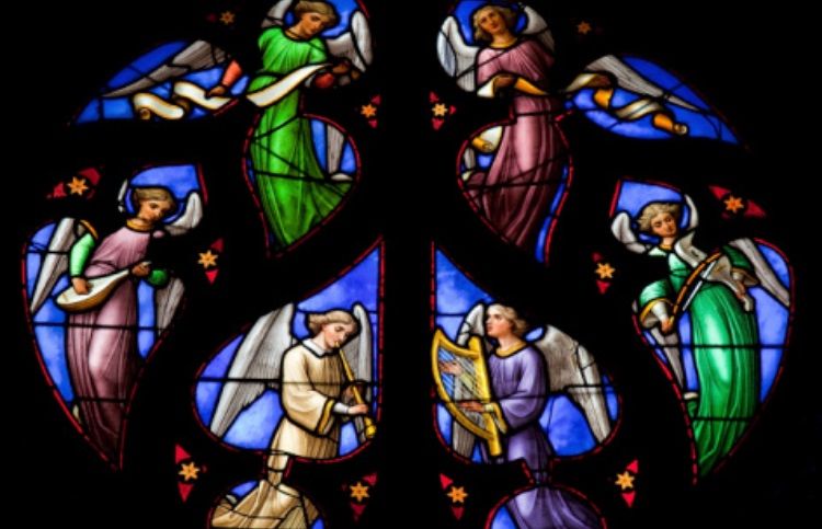 Stained glass detail of angels playing instruments.