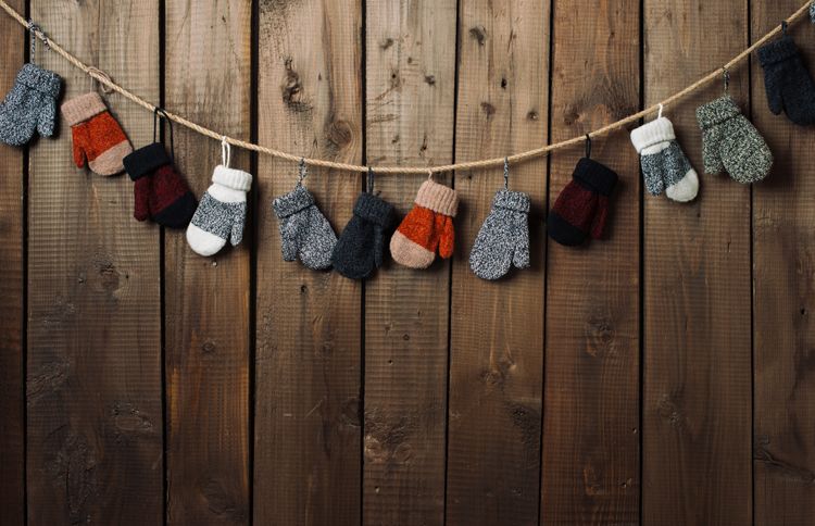 Guideposts: A collection of mittens are hung to dry along a wall