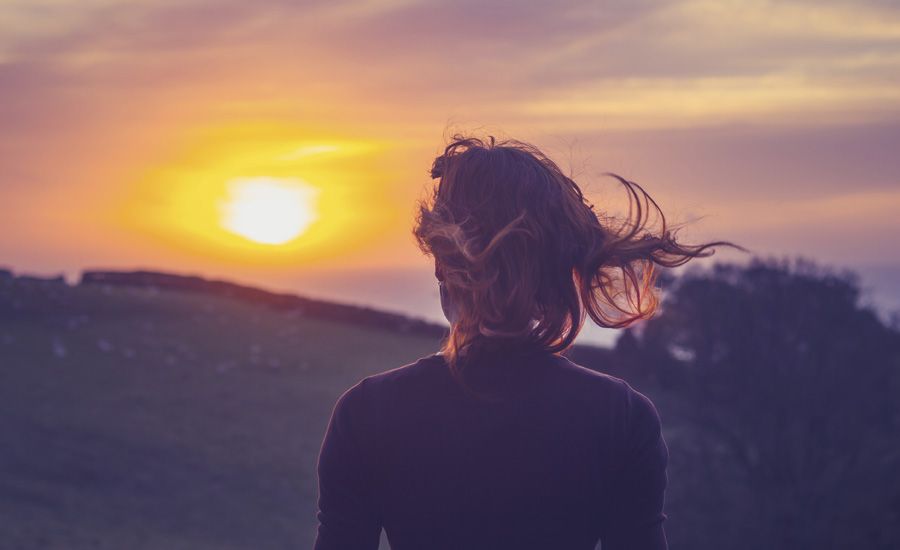 Woman looking at the sunset with wonder