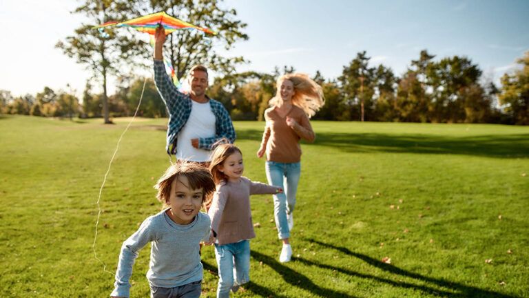 Family flying a kite together during spring
