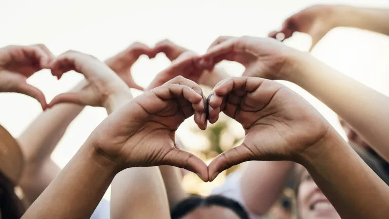 Hands holding up heart shapes for Easter acts of kindness