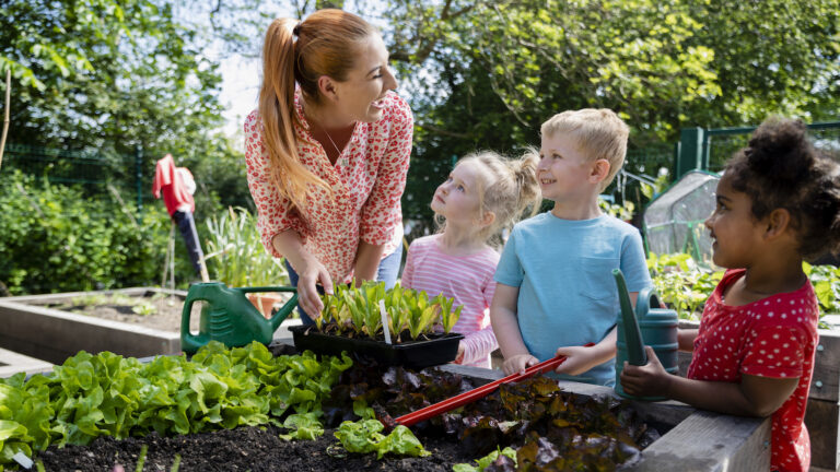 Woman and kids working in their spring garden together
