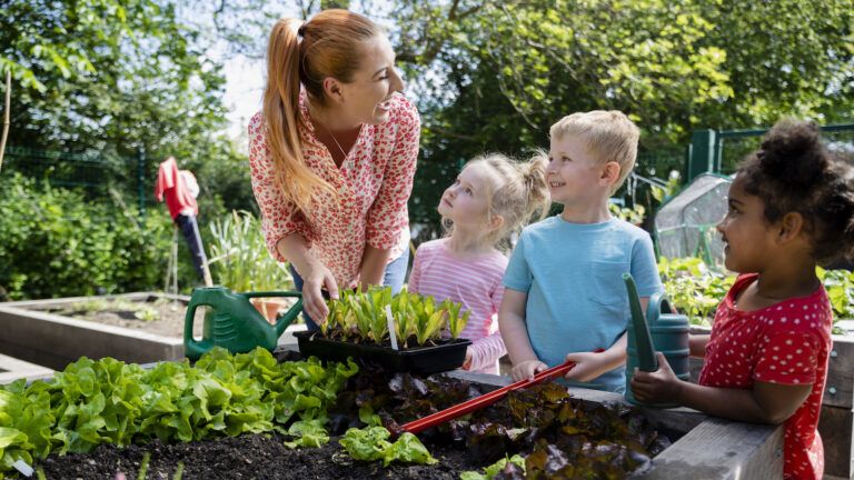 Woman and kids working in their spring garden together