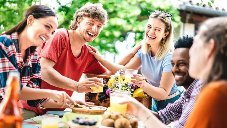 Young people laughing during dinner for their Easter acts of kindness