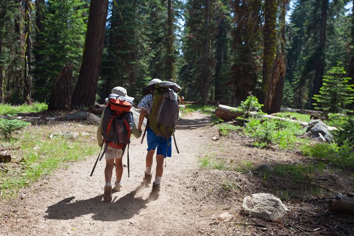Guideposts: Parent and child hold hands as they hike in the woods.