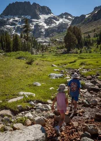 Guideposts: Rebekah and Cade across an open meadow with snow-capped mountains in the distance