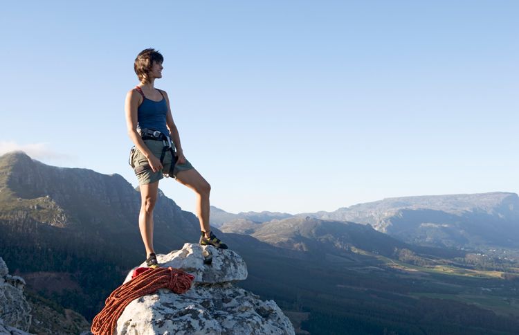 Guideposts: A woman stand atop a mountain's peak, gazing out at the world below