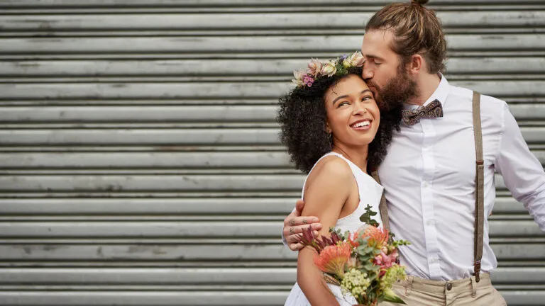 Married couple hold each other outside at their wedding