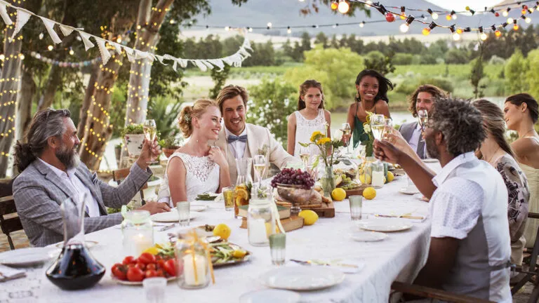 Wedding party says a blessing to the bride and groom at dinner