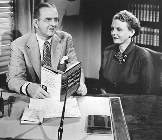 Dr. Norman Vincent Peale, with a copy of The Power of Positive Thinking in his hand and his wife, Ruth, at his side