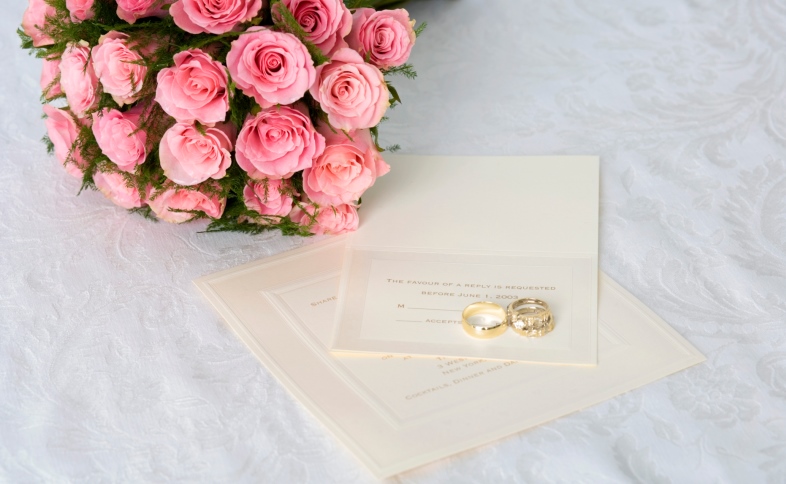 Wedding blessings written on paper with gold rings and flowers