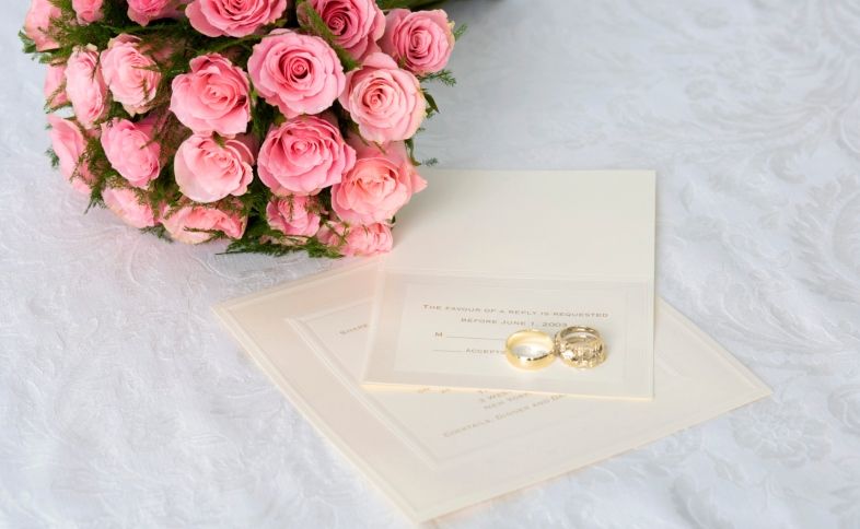 Wedding blessings written on paper with gold rings and flowers