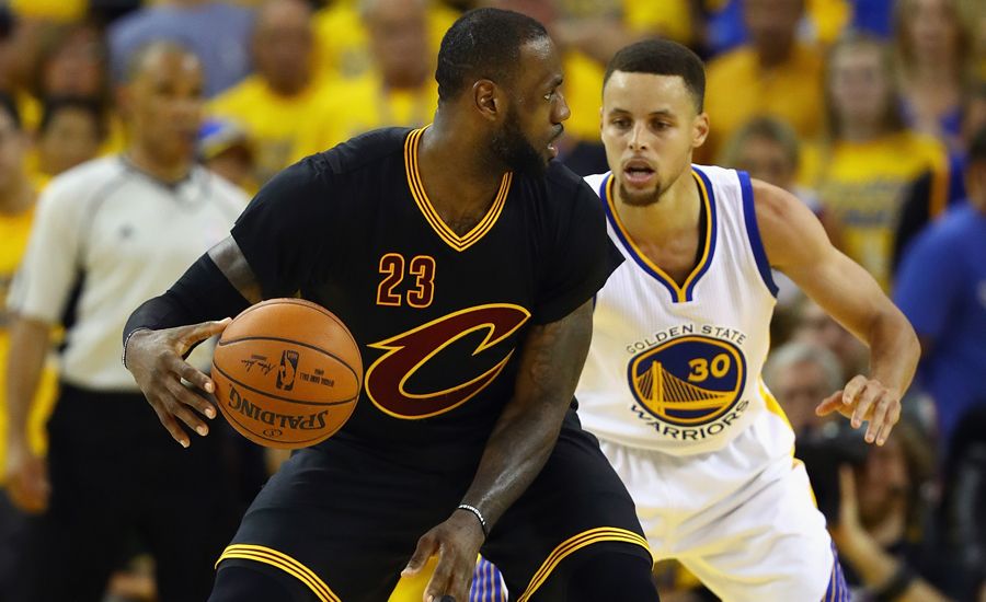 Golden State's Stephen Curry closely guards Cleveland star LeBron James