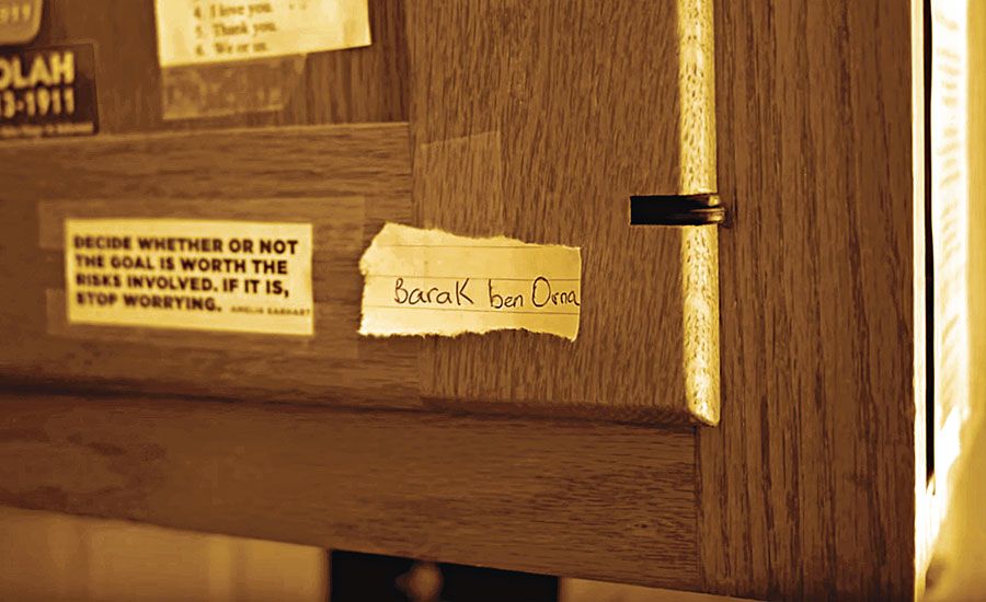 Barak ben Orna's name on a scrap of paper taped to a kitchen cabinet