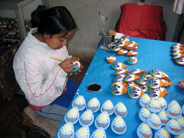 A young woman paints a traditional Peruvian instrument call the ocarina.