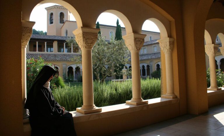 A nun sits quietly within the Abbaye Notre-Dame de l'Annonciation