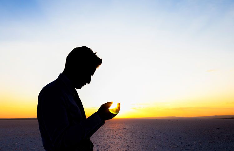 Man standing in front of the horizon praying