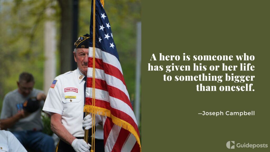 A veteran holding an American flag with a quote by Joseph Campbell