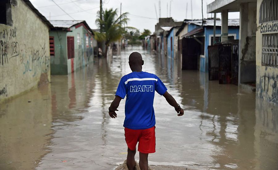 A child walks through flooded streets in Haiti