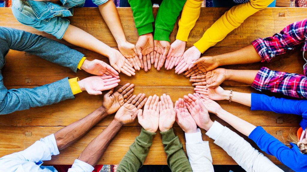 A circle of hands of people of different cultures displays a spirit of generosity