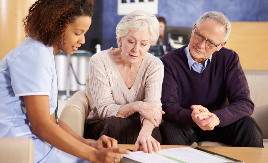 A mature couple reviews Medicare documents with a health practitioner