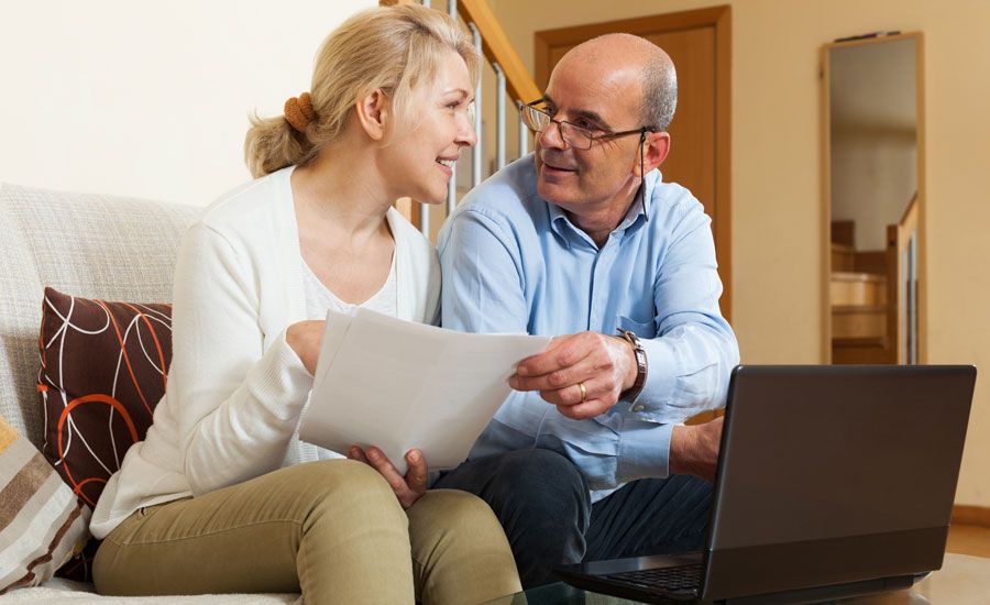 A mature couple pores over Medicare documents and the Medicare website