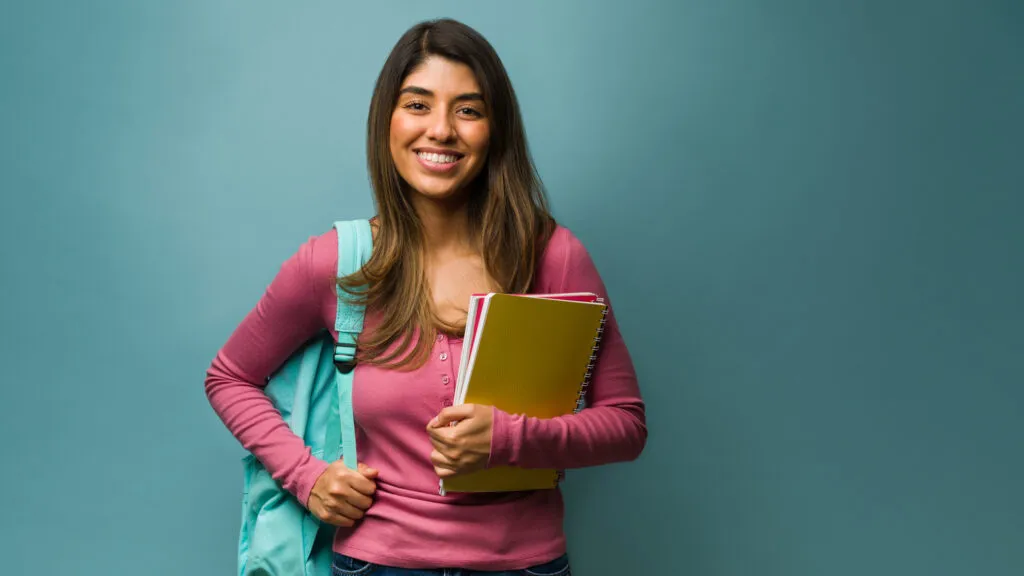 Girl in a pink sweater and backpack going to school with New year quote for students