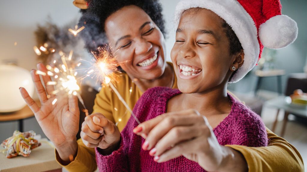 Mother and daughter with sparklers saying a funny new year quote