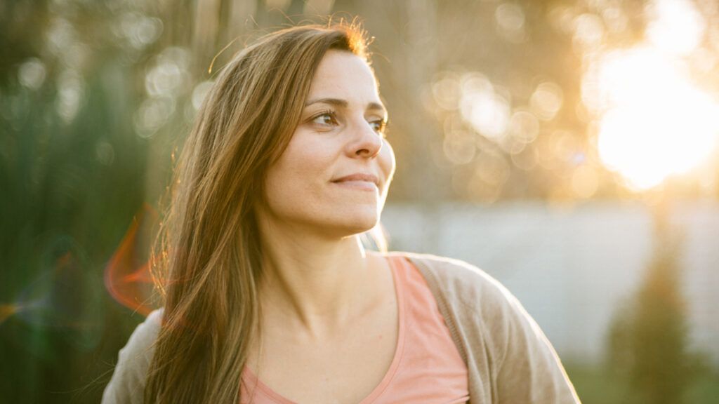 Woman outside at sunrise looking at a new year quote for second chances
