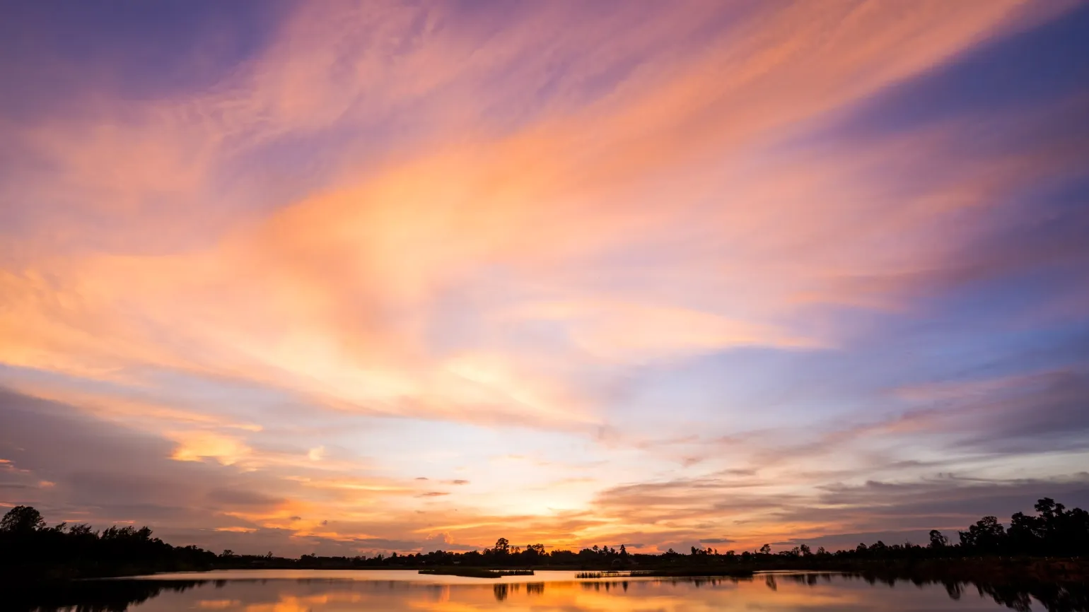 The sunrise and clouds over a lake with a New Year prayer about God